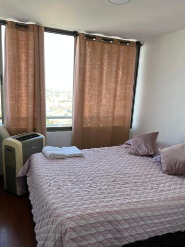 a bedroom with a bed and a large window at Acogedor Depto excelente vista, A/C in Santiago