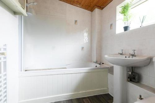 a bathroom with a bath tub and a sink at Emerald House Leisure & Contractors in Peterborough