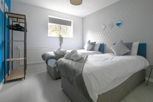 a bedroom with three beds and a mirror at Emerald House Leisure & Contractors in Peterborough