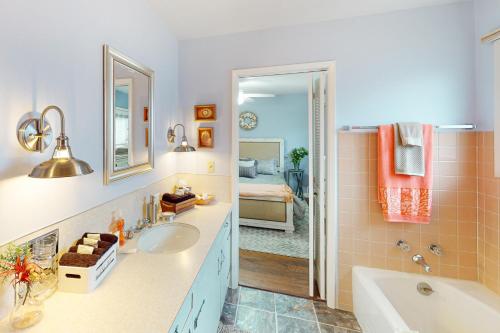 un bagno con vasca, lavandino e specchio di The Bluff Cottage a Port Angeles