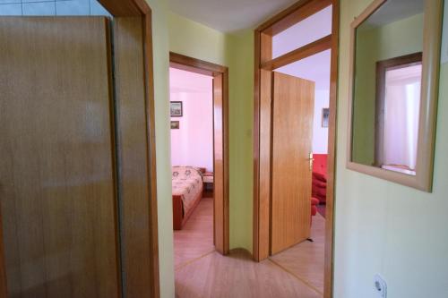 Una puerta que conduce a una habitación con dormitorio en Apartments Fejer, en Njivice
