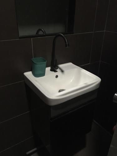 a bathroom with a white sink and a mirror at The Grayish Melaka in Melaka