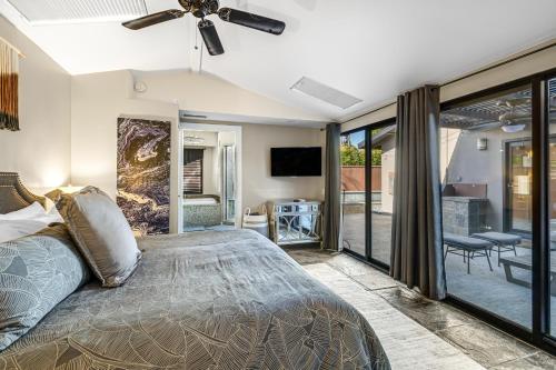 een slaapkamer met een bed en een plafondventilator bij Movie Colony East Eden Permit# 3625 in Palm Springs