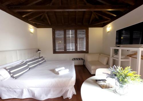 a bedroom with a large white bed and a couch at ISA Granada in Granada