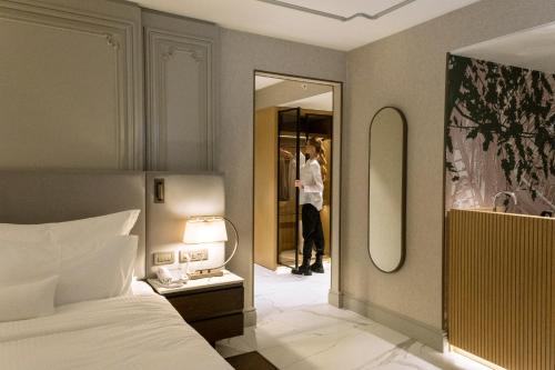 a woman taking a picture in a mirror in a bedroom at Stayso The House Hotel in Istanbul