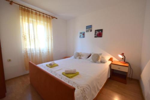 1 dormitorio con 1 cama con 2 toallas en Apartments Fejer, en Njivice