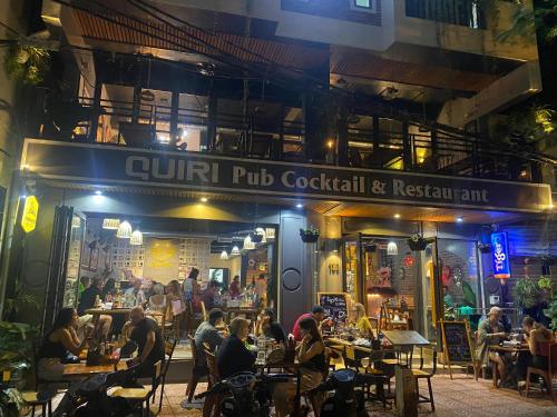 people sitting at tables outside of a restaurant at night at Quiri Hotel in Cat Ba