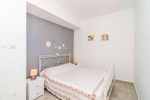 a white bedroom with a bed in a room at Sea view apartment 10 minutes walk from old city in Dubrovnik
