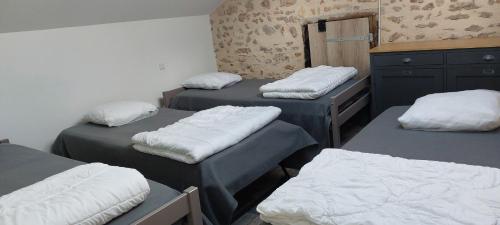 a room with three beds and a dresser at Gîte le Hameau des Bordes 4 étoiles in Nouaillé-Maupertuis
