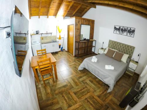 1 dormitorio con 1 cama y suelo de madera en Tacuifi I - Apartamentos en Los Reartes