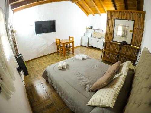 1 dormitorio con 1 cama grande y 1 mesa en Tacuifi I - Apartamentos en Los Reartes