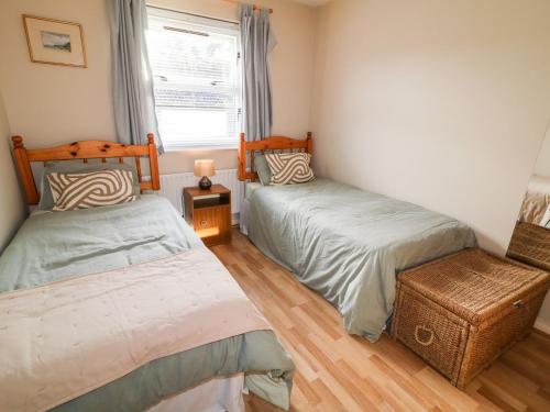 1 dormitorio con 2 camas individuales y ventana en 17 Buninver Road en Omagh