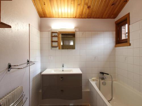 a bathroom with a sink and a bath tub at Chalet au Mont-Dore, 300m du centre, 6 pièces, garage, terrain pentu, idéal 8 pers, animaux non acceptés. - FR-1-608-4 in Le Mont-Dore