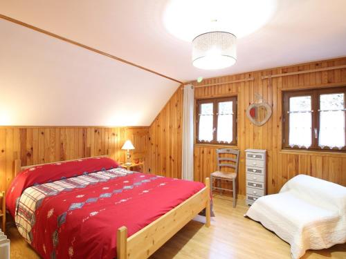 1 dormitorio con paneles de madera, 1 cama y 1 silla en Maison Mont-Dore, 6 pièces, 8 personnes - FR-1-608-4, en Le Mont-Dore