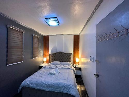 niewielka sypialnia z łóżkiem i 2 lampami w obiekcie Clark pampanga( dale’s crib) w mieście Mabalacat