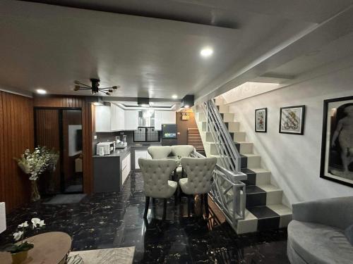 - un salon avec un escalier, une table et des chaises dans l'établissement Clark pampanga( dale’s crib), à Mabalacat