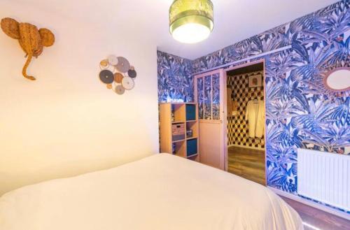 a bedroom with a bed and a blue and white wall at Appart hôtel le 8 Spa&Jacuzzi in Mâcon