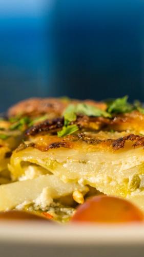 Een close-up van een stuk pizza op een bord. bij Maleme Mare in Maleme