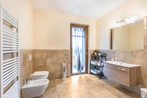 bagno con lavandino, servizi igienici e specchio di La Siesta a Villafranca di Verona