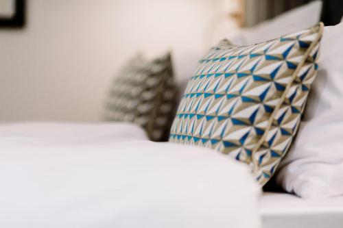 a white couch with a blue and white pillow on it at Artist hotel in Subotica