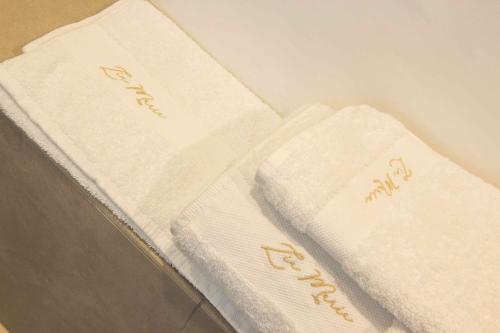 three white towels sitting on top of a table at Zia Maria in Fasano