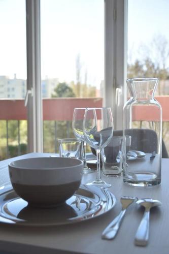 - une table avec une assiette et des verres à vin dans l'établissement RARE : Calme et détente à Nantes !, à Nantes