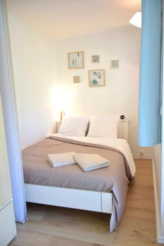 une chambre avec un lit avec deux serviettes dessus dans l'établissement RARE : Calme et détente à Nantes !, à Nantes