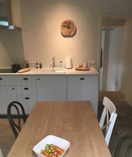 a kitchen with a table and a sink with a plate of fruit at La Relique ( woning voor 4 tot 6 personen ) in Bouillon