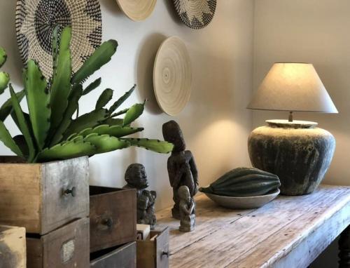 a table with a lamp and a plant on it at La Relique ( woning voor 4 tot 6 personen ) in Bouillon