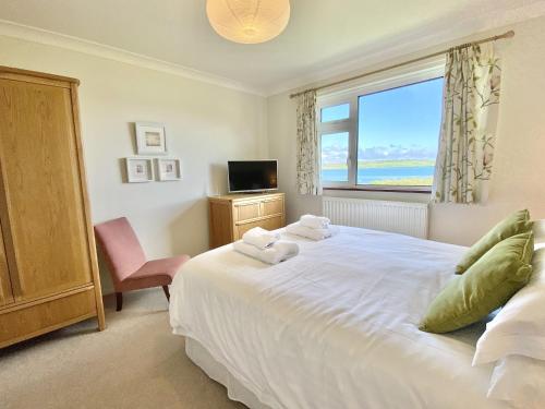 a bedroom with a large white bed and a window at Myebon in Padstow