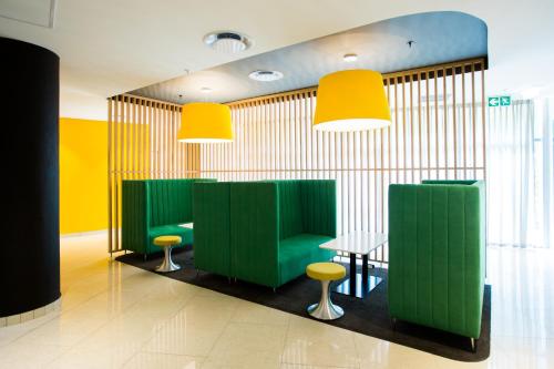 a restaurant with green and yellow walls and a table and stools at Park Inn by Radisson Libreville in Libreville