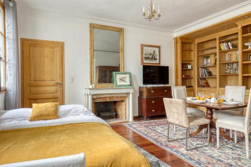 um quarto com uma cama, uma mesa e uma lareira em Bohemian & Authentic Parisian Flat - Paris 07 em Paris