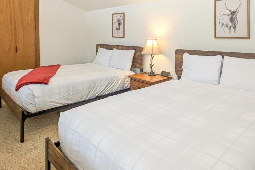 a bedroom with two beds and a table with a lamp at Golf Creek 32 in Teton Village
