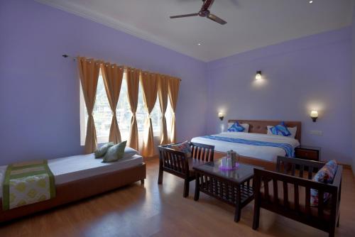 a bedroom with a bed and a couch and a table at Hotel Vista Bhowali, Nainital - Vegetarian in Bhowāli