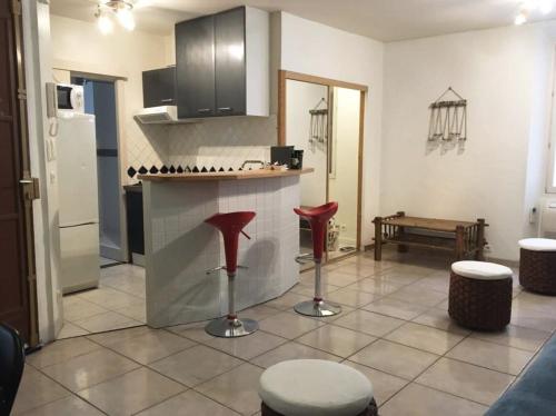 une cuisine avec un comptoir et des tabourets rouges dans l'établissement C087-Comfortable apartment in the heart of Cannes, à Cannes