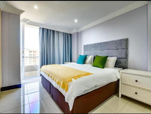 a bedroom with a large bed and a window at The Sails Apartment in Durban