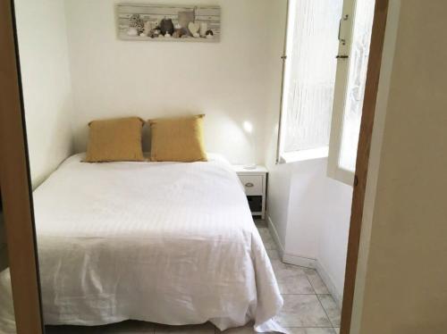 une chambre avec un lit blanc avec deux oreillers dessus dans l'établissement C087-Comfortable apartment in the heart of Cannes, à Cannes