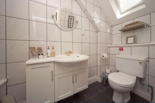 a white bathroom with a toilet and a sink at Loch Melfort Hotel in Ardfern
