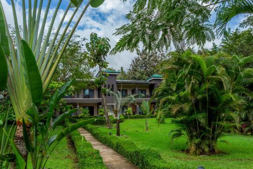 a house in the middle of a garden with palm trees at Leyenda Boutique Hotel & Spa in Sámara