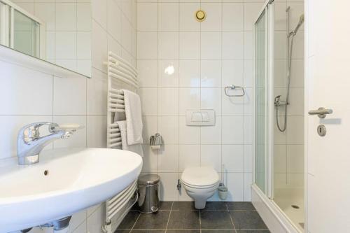 a white bathroom with a sink and a toilet at Lakeside-Apartment-1 Grand appartement familial avec 2 terrasses et vue panoramique in Vevey