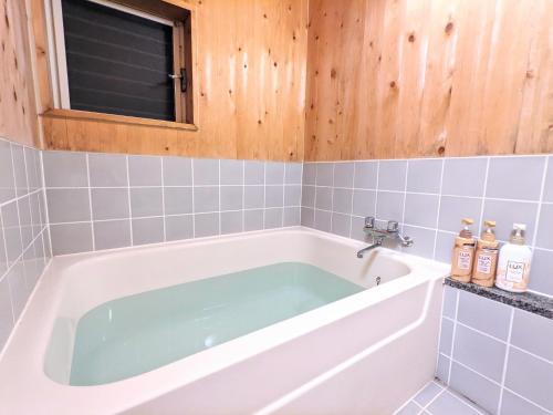 a bath tub in a bathroom with a window at Mimoza Retreat NASU in Nasushiobara