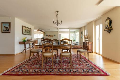 a dining room with a table and chairs on a rug at Lakeside-Apartment-1 Grand appartement familial avec 2 terrasses et vue panoramique in Vevey