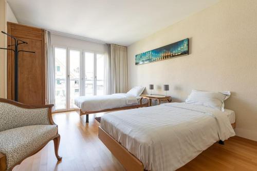 a hotel room with two beds and a window at Lakeside-Apartment-1 Grand appartement familial avec 2 terrasses et vue panoramique in Vevey