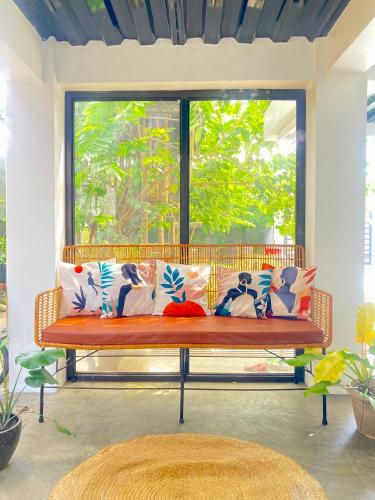 a bench with pillows in front of a window at Balai Lawaan Cozy Homestay in Iloilo City