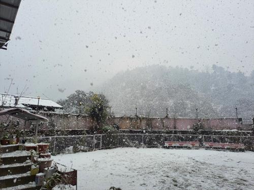 a snow covered field with a train in the background at Hotel Vista Bhowali, Nainital - Vegetarian in Bhowāli