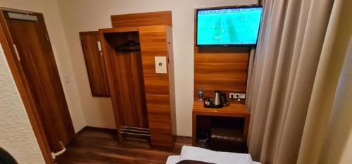 a small room with a television and a room with at Hotel Frankfurt Messe in Frankfurt/Main