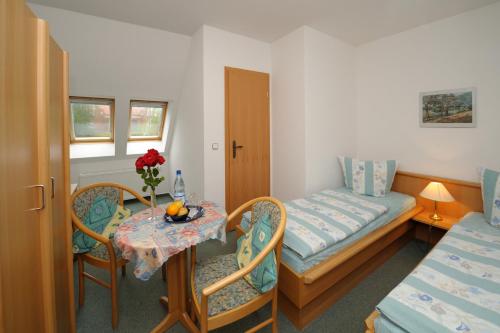 Habitación pequeña con mesa pequeña y cama en Pension Schwark en Bad Doberan
