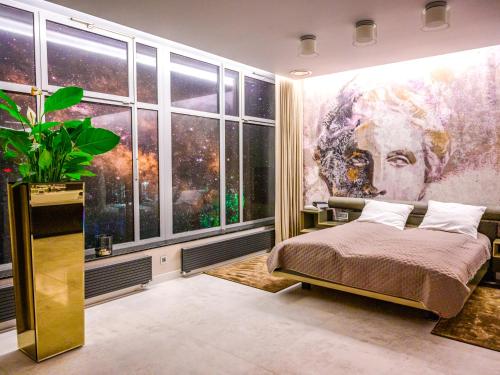 羅茲的住宿－Pietryna Apartments Luxury - Sauna , Jacuzzi , Bezpośrednio przy ul Piotrkowskiej，卧室的墙上挂着一幅大画