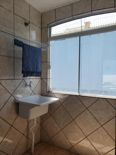 baño con lavabo y ventana en Casa Miosótis apartamentos, en Palhoça