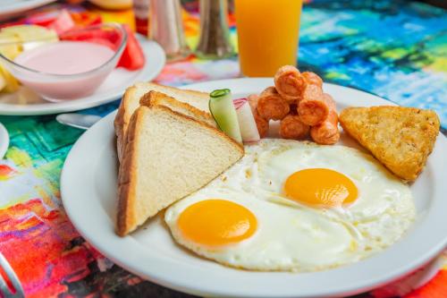 a plate of eggs and toast with bread and tater tots at Leyenda Boutique Hotel & Spa in Sámara